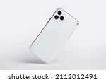 Small photo of Silver iPhone 11 and 12 Pro max in clear silicone case falls down back view, phone case mockup isolated on gray background
