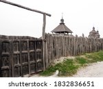 Stockade fence made of logs. Protective structure for the protection of a wooden fortress. Fence and strengthening of the ancient medieval fortress fence of sharpened wooden logs