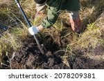 Small photo of Digging with a shovel in the forest. The man is digging the ground. Dig up the treasure. Search for metal. Dig the ground.
