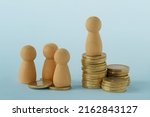 Small photo of Pawns with stacks of coins - Concept of social and economic inequality