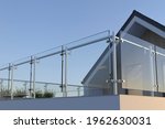 Modern stainless steel railing with glass panel and house, 3D illustration