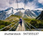Amazing Nature of Hooker Valley Track in Mount Cook, New Zealand. Young Family walk on Suspension Bridge.