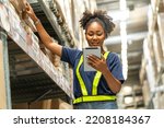 Small photo of African American woman working with a tablet walks through the warehouse to check inventories and attach a barcode to deliver logistics to customers in a warehouse.