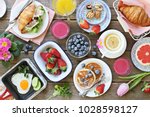 Breakfast food table. Festive brunch set, meal variety with fried egg, pancakes, croissants, smoothie ,fresh berries and fruits. Overhead view