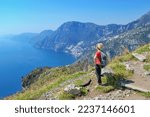 Small photo of Woman hiker watching beautiful costal scenery - Path of the Gods "Sentiero degli Dei" the famous costal hiking trail, Amalfi Coast, Italy
