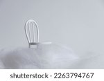 Miniature chair in surreal scenery with synthetic clouds on white background
