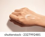 Small photo of Cosmetic smudge texture on woman hand beige background