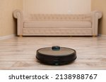 Robot vacuum cleaner is cleaning the floor in the living room.