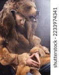Small photo of Caveman in bearskin, serious bearded man, medieval cosplay