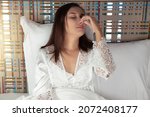 Small photo of Thai woman in a white nightgown on the bed suffering from sinus pressure at night. People caught a cold and fever. The concept of healthcare and allergy
