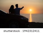 The man and woman standing near the car on the beautiful sea shore background