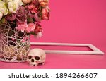 Small photo of flowers and skull on a pink background, subtext on love and death