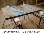 Small photo of Craft manufacturing of exclusive wooden tables. Workshop for the production of countertops with elements of epoxy resin. A dusty tabletop in a woodworking shop after sanding.