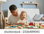 Small photo of Imaginative storytelling games. Cognitive puzzle challenges. Montessori teaching method. Baby girl playing sorter with her father in living-room.