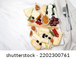 elegant serving cheese board with pecorino cheese brie goat cheese with crackers and grissini breadsticks, Italian and French cheese with figs jam olives and berries