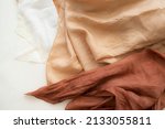 Small photo of hand dyed clothes in warm natural tones on a bright background - text space - slow fashion concept