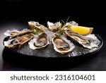 Small photo of Platter of fresh oysters on a bed of ice. Oysters with lemon and sauce. Several oysters on a tray with caviar. Food in a restaurant. A bowl of oysters with caviar.