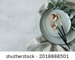 Modern minimal table place setting neutral green color on gray concrete background top view. Space for text .  Modern kitchen.Scandinavian style tableware.Business food brand template.