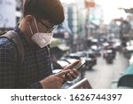 Concept of coronavirus quarantine. MERS-Cov, Novel coronavirus (2019-nCoV), man with medical face mask using the phone to search for news.Air pollution 