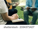 Small photo of Christian Bible Study Concepts. Christian friend groups read and study the bible together in the park. sharing the gospel with a friend and holding each other's hand praying together. praying to God