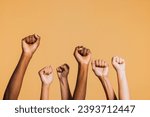 Small photo of Hands raised with closed fists. Diverse coloured hands raised up with closed fist symbolizing power, determination.