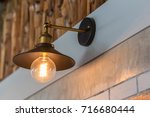 Small photo of Zooming closeup view of a charming electrical hanging lamp on a beautiful decorative wall consists of linear cement snd blurted timber pattern inside a local rural modern restaurant in Thailand