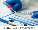 Medical NHS worker holding Coronavirus COVID-19 NP OP LFT swab sample test kit,nasal collection equipment submitting form,reverse transcription RT-PCR DNA molecular nucleic acid diagnostic procedure 