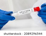 Small photo of Medical NHS healthcare professional holding COVID-19 swab collection kit, wearing white PPE protective suit and gloves,test tube for taking Omicron patient specimen sample,PCR testing protocol process