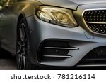 headlight and radiator grille of a beautiful matte gray car with yellow tint