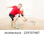 Two men playing match of squash. Closeup of squash players in action on squash court 
