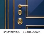 Small photo of Classic wood entrance door in dark blue with carved panels and gold patina