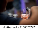 hand with a glass of rosé wine at a wine tasting