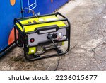 Small photo of Portable electric generator running in the cold winter.Energy genocide. Power outage as a result of missile strikes by Russia on energy facilities of Ukraine. Small business use gasoline generators.