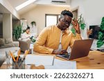 Small photo of Portrait of an african american man looking into laptop and planning future while solving problems and making a financial plan. Online banking, paying rant and bills. Headache and stress.