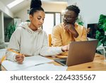 Small photo of Diverse couple looking into laptop and planning their future while making a financial plan. Online banking, paying rant and bills. Copy space. Diversity.