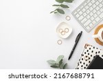 Small photo of Business concept. Top view photo of workstation keyboard black and white stationery trendy planners pen cup of coffee on rattan placemat gold rings and green eucalyptus on isolated white background