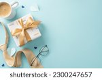 Small photo of Elegant Father's Day display. Flat lay top view of gift box, necktie, spectacles, coffee mug, men accessories, and blank space for text on pastel blue background