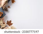 Indulge in cozy autumn comfort at home: Top view photo featuring a warming cashmere plaid, maple foliage and pinecones on a white isolated background. Copyspace available for text or adverts