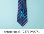 Small photo of Men's Health Advocacy. Top view of prostate cancer awareness emblem - blue ribbon, attached to necktie - on a soft blue background, with space for text or promotions
