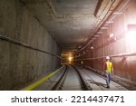 Small photo of Soft focus of tunnel. Engineers wear helmet, vests safety .Technician control underground construction at working shaft to maintenance. Transport pipeline by Tunnel Boring Machine method for train.