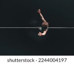 Small photo of A tightrope walker walks along a line above the water. extreme sports
