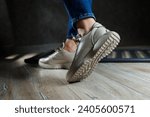 Small photo of Beige women's sneakers. Collection of women's leather shoes. Female legs in leather beige casual sneakers. Stylish women's sneakers.