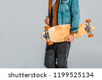 cropped view of stylish skateboarder holding longboard isolated on grey