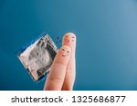 cropped view of happy couple of fingers with condom isolated on blue