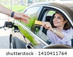 selective focus of happy woman sitting in car and giving credit card to worker at gas station 