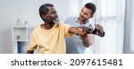 Small photo of young physiotherapist assisting smiling african american patient exercising with dumbbell, banner