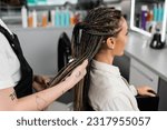 hair professional, tattooed beauty worker holding braids of female client in salon, beauty industry, salon job, customer in salon, hairdresser, salon services, hair make over