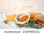 Small photo of sea buckthorn tea in a see-through teapot, a healthful brew. sea buckthorn tea, a tasty and medicinal beverage tea time with fresh sea buckthorn leaves and berries