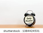 Post it word daily routine alarm clock on wood desk white background. 
Sticker notepad paper message daily routine and watch on wooden table for copy space. 
