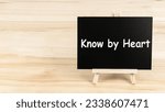 Small photo of Text sign showing know by heart blackboard on wood desk background. Chalkboard words write know by heart on table for copy space.